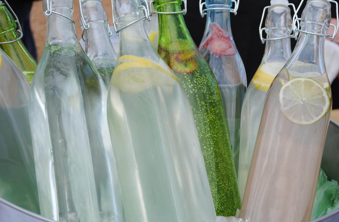 glass soda bottles with lemons lime and strawberries