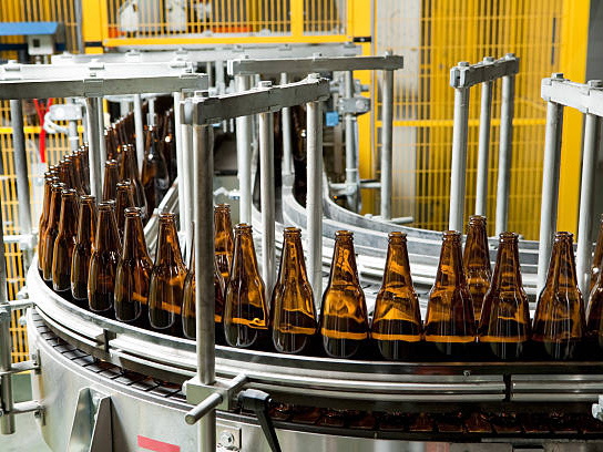 filled glass bottle on conveyor belt
