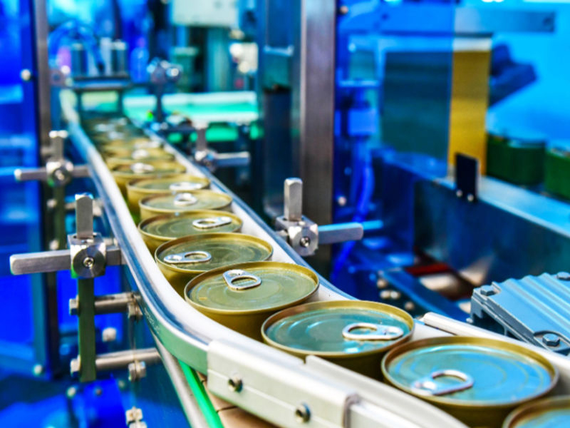 filled sauce can on conveyor belt