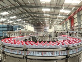 Filled bottles moving through a MIC beverage production line.